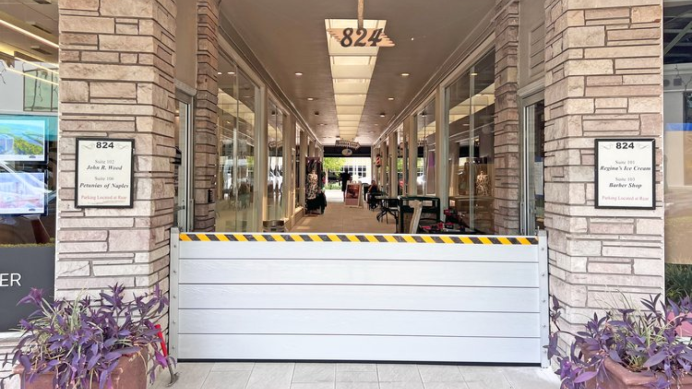 Aluminum flood plank barrier installed at a commercial building entrance to block floodwaters.
